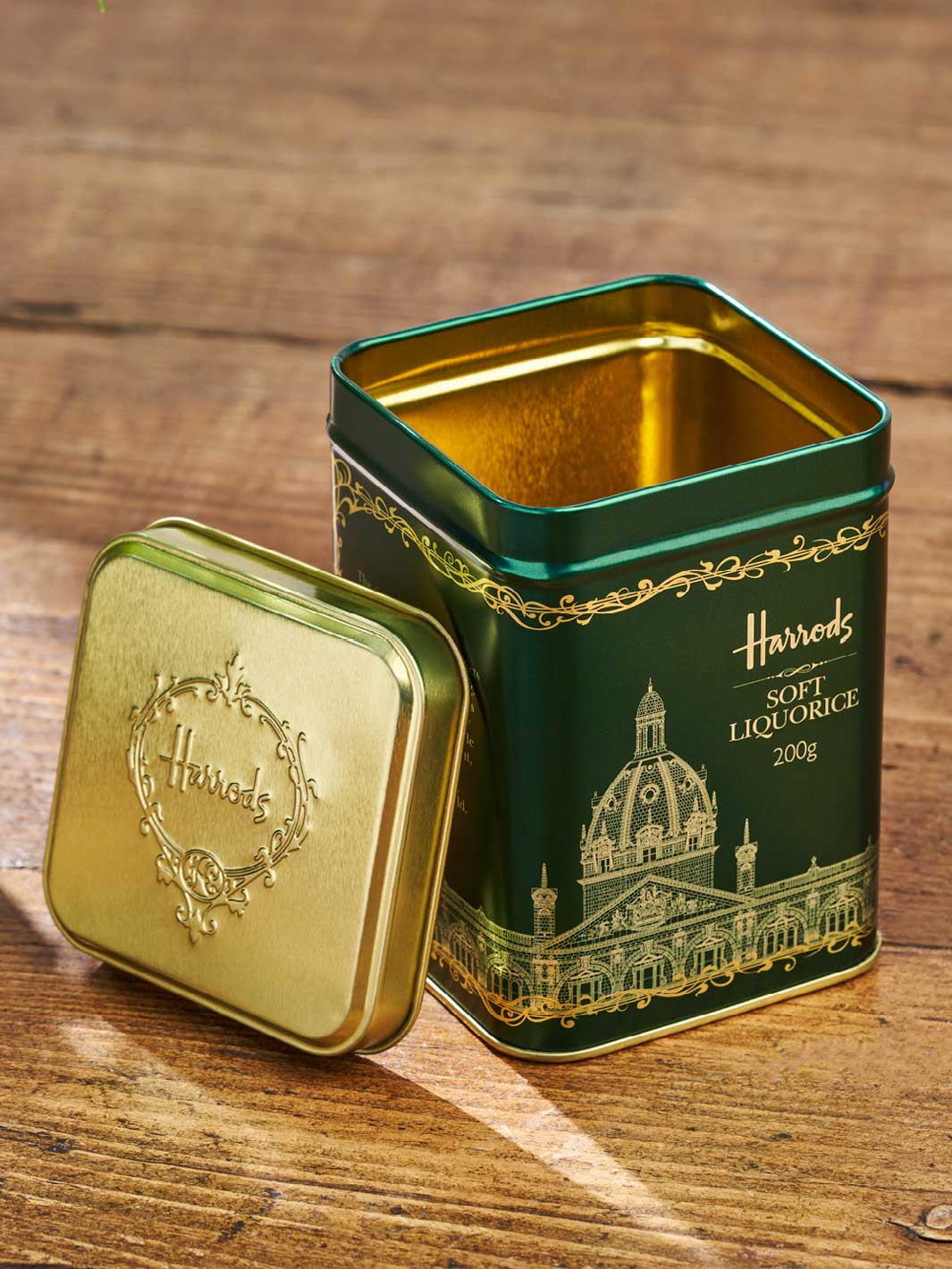 Eine grüne Harrods-Verpackungsdose für Süßigkeiten. In das grüne Design ist Gold eingraviert.