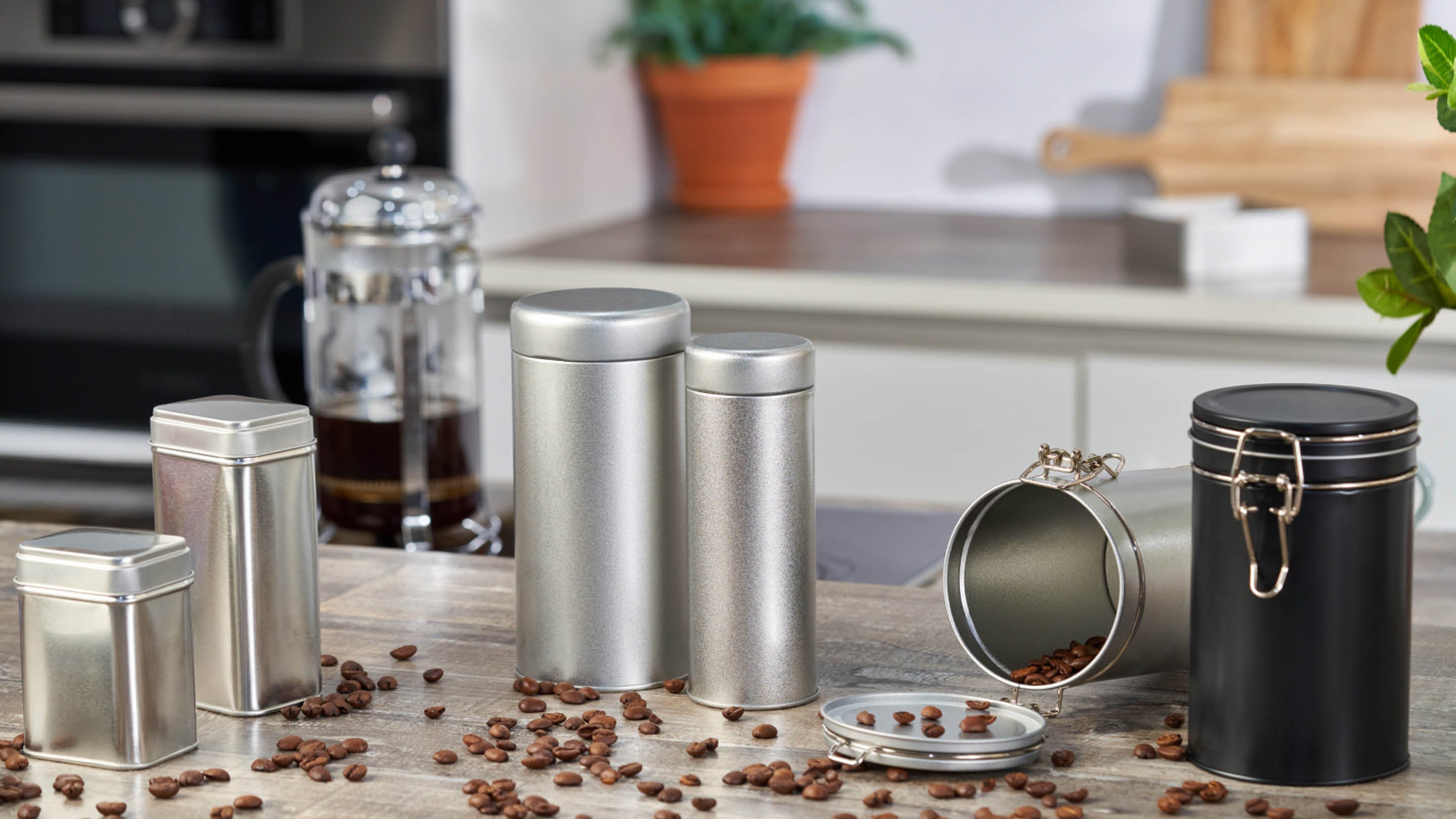 Eine Reihe von Metallverpackungsbehältern für Kaffee, Gewürze und Kräuter in der Küche.