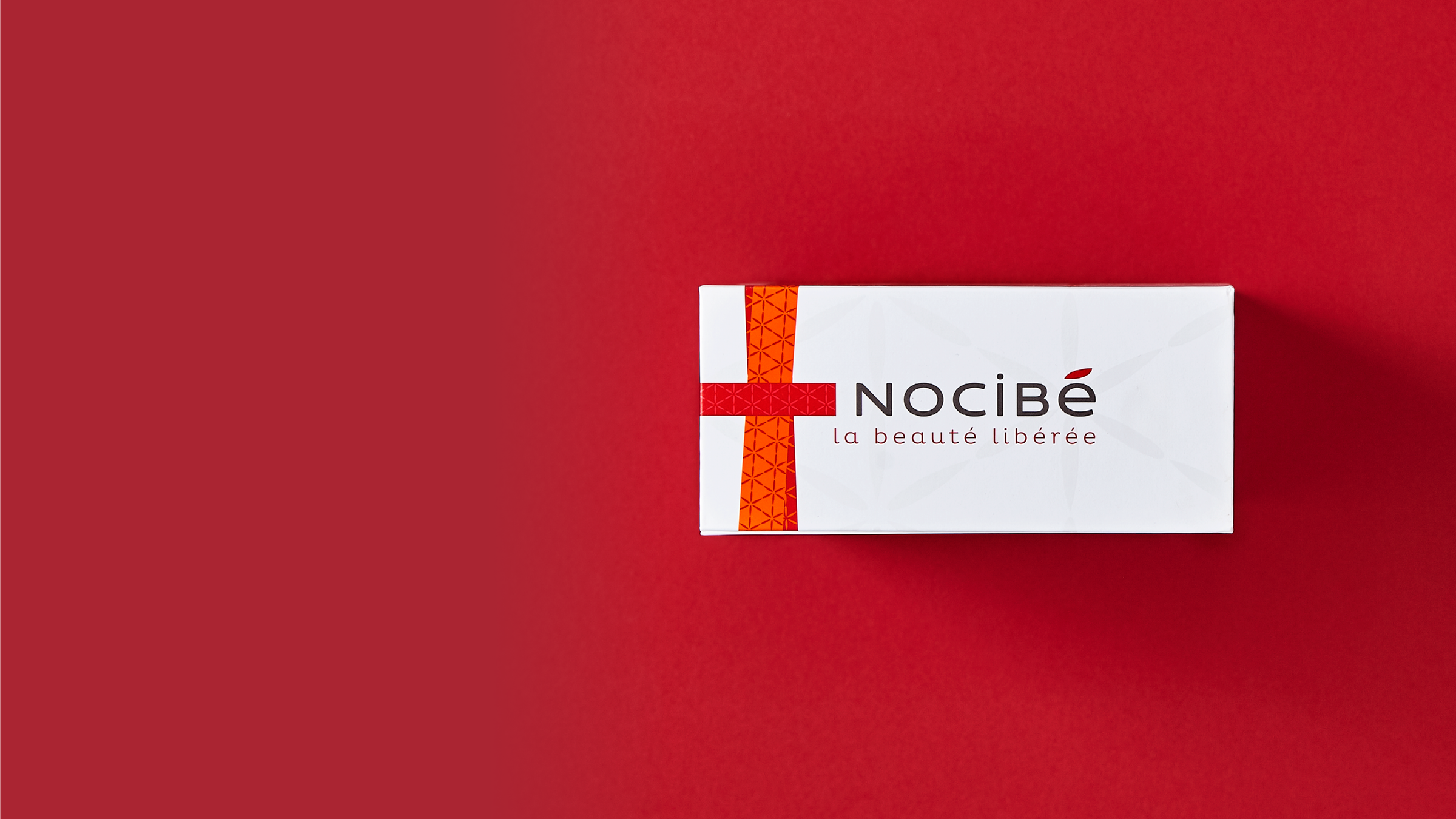 Eine weiße Pappschachtel mit Magnetverschluss für Nocibe vor rotem Hintergrund
