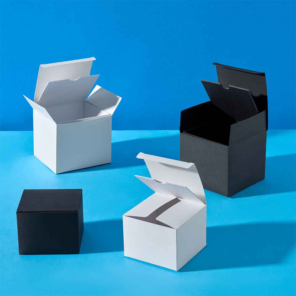 Sammlung von Geschenkboxen aus Karton in Schwarz und Weiß auf blauem Hintergrund