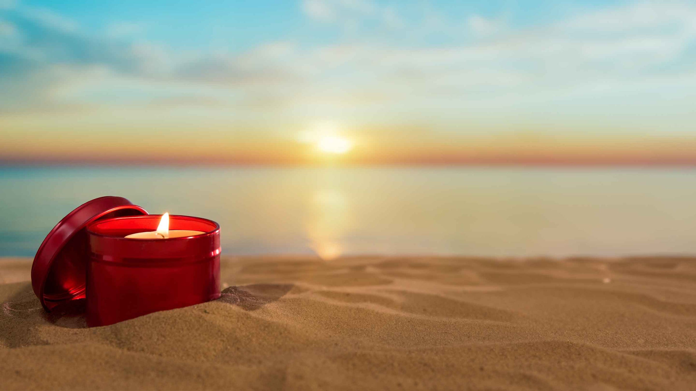 Rote Kerzenverpackung an einem Strand