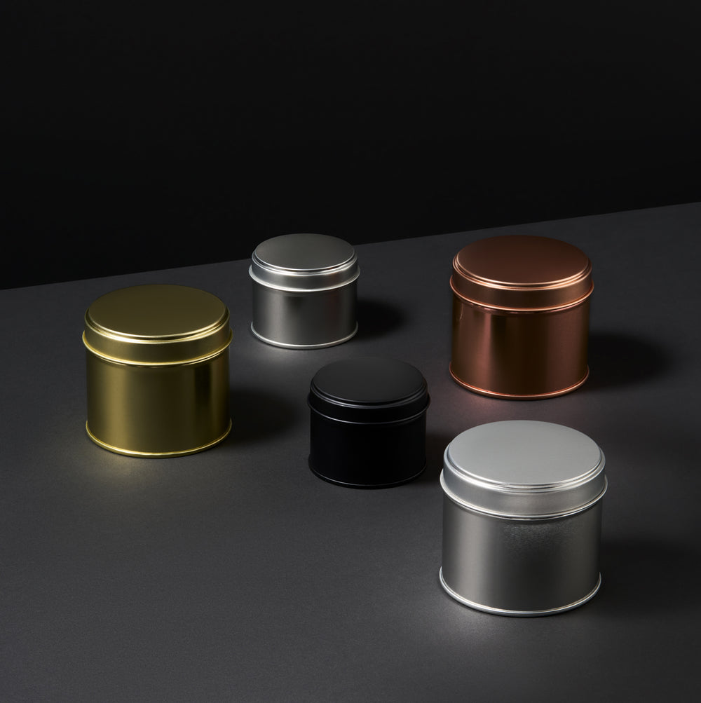 Kollektion von Blechdosen mit verschweißten Seitennähten in Schwarz, Roségold, Silber und Gold
